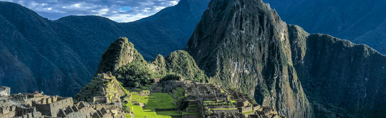 View of Machu Picchu ruins in Peru, showcasing ancient stone structures against a backdrop of lush green mountains