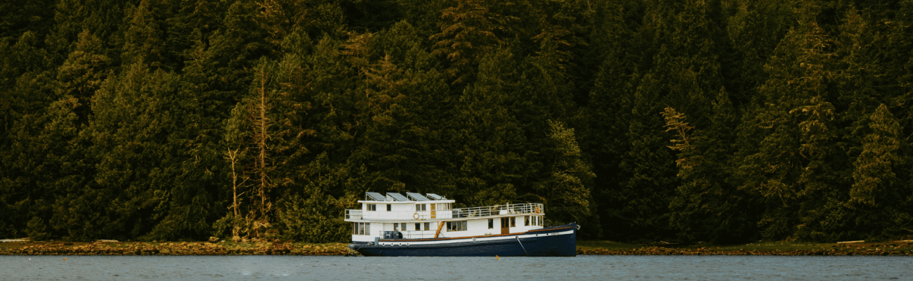 A boat is floating in the water near some trees